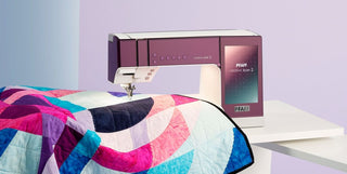 A sewing machine with a quilt on top of it.