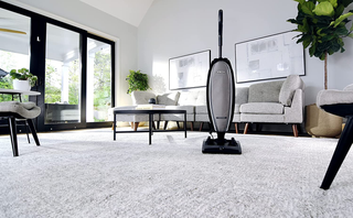 A living room with a vacuum cleaner on the floor.