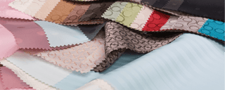 A collection of fabric swatches featuring various patterns and colors, including shades of pink, blue, green, red, and beige, displayed in overlapping layers.