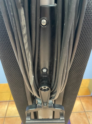 Close-up of a Riccar R10S vacuum cleaner by Sew & Vac, showing the cord wrapped neatly around the hooks on the back of the machine, featuring a sturdy metal brush roll and 2 speeds for versatile cleaning.
