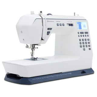 The Husqvarna Viking Onyx 30 from Imagine Sewing & Vacuum is a white computerized sewing machine featuring an LCD screen, button controls, a base ruler, and over 150 stitch options for creative versatility.