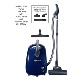 The image shows a dark blue mid-size SEBO Airbelt E2 Turbo canister vacuum from Sew & Vac with an attached hose, turbo head, parquet brush, and additional onboard cleaning tools. Model number #91620AM is displayed. This vacuum features excellent filtration and protective rubber-coated wheels for added convenience.