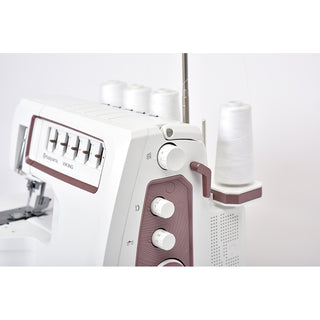 Close-up of the Husqvarna Viking Amber Air S500 from Imagine Sewing & Vacuum, showcasing multiple control dials, air threading, and four large spools of white thread.