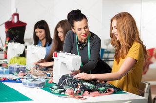 A group of young women sewing on Sew & Vac machines in an Open Sew Thursdays sewing studio event photo.