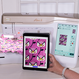 A person using a Baby Lock Altair 2 Sewing & Embroidery Machine with IQ Technology to control an embroidery machine.
