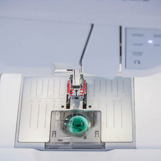Close-up of the needle and presser foot area on the Husqvarna Brilliance 75Q by 38-SVP - Singer Viking Pfaff, highlighting its metal plate, transparent bobbin, and detailed exclusive stitching techniques.