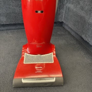 The 2-Miele Miele Salsa Upright CR vacuum cleaner, shown from the front, features strong pet hair suction and is displayed on a gray carpeted floor.