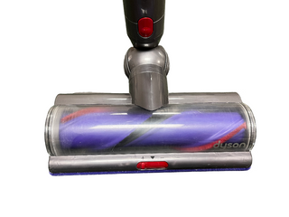 A close-up of the Dyson Cyclone v10 Animal vacuum cleaner brush head with a purple roller brush and red and black accents, displaying the Dyson logo. Sold by Sew & Vac, this certified refurbished vacuum ensures top-notch performance.