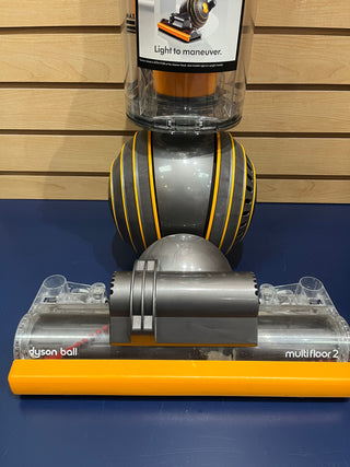 Close-up of the front part of a Sew & Vac Dyson UP19 Multifloor 2 vacuum cleaner on display, featuring its ball mechanism and a light to maneuver guide. This unit is certified refurbished with brand new filters, making it almost like new.