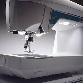 A white Husqvarna Opal 650 sewing machine with a light on it.