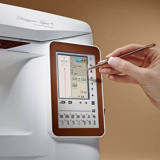 A hand uses a stylus on the touchscreen of the Husqvarna Viking Designer Topaz 40, accessing advanced embroidery design editing features.