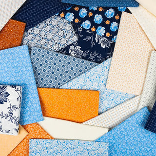 The Denim Halloween Figs Quilt Kit by 41-Sew Steady features Denim & Daisies fabrics in blue, orange, and white floral and geometric designs—ideal for a vibrant and colorful quilt top.