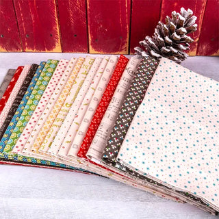 A vibrant array of patterned fabric pieces from the Let's Make a Snowman Sew Along Quilt Kit Featuring Home Town Holiday by Lori Holt from Sew & Vac is neatly arranged against a wooden background, with a snow-dusted pinecone on the right side.