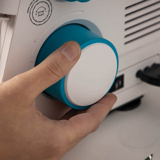A person is holding a blue button on a PFAFF Admire Air 5000 sewing machine.