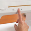 A person is pointing at a Baby Lock Jazz II Sewing and Quilting Machine.