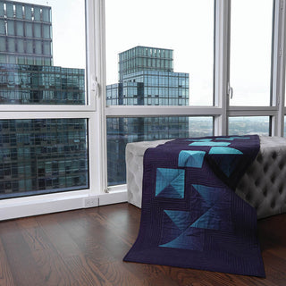 A Pfaff Ambition 610 Sewing and Quilting Machine on a bench in front of a window.