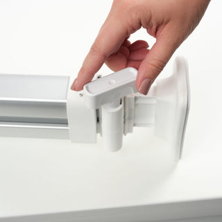 A hand adjusts a Singer Ditto Pattern Projector wall bracket, ideal for supporting digital projection or paperless patterns.