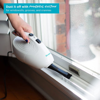 A person cleaning a window with a Simplicity FLASH Micro Vacuum.