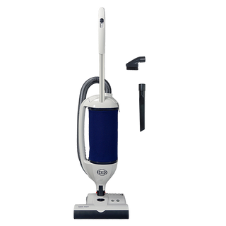 The SEBO Dart w/ET-1 Power Head (White) vacuum cleaner by SEBO features a dark blue dust bag, S-Class sealed filtration, an attached hose, and two detachable nozzle attachments, all shown on a plain white background.