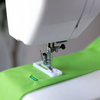 A Baby Lock Zest Sewing Machine with a green fabric on it.