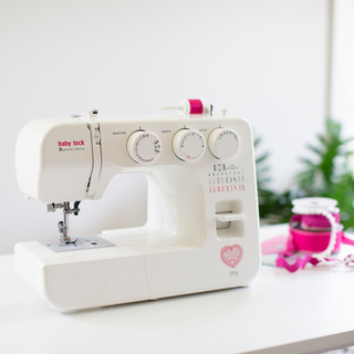 A Baby Lock Joy Sewing Machine sits on a table.
