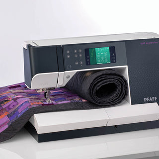 A PFAFF Quilt Expression 720 Sewing and Quilting Machine with a quilt on top of it.