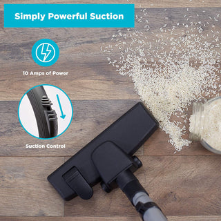 The simplicity Jill Canister Vacuum Cleaner head is shown cleaning spilled rice from a wooden floor, featuring 10 amps of strong suction and easy suction control.