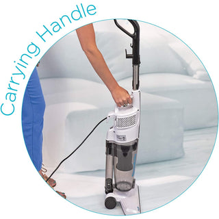 A woman is holding a Simplicity S60 Spiffy Broom Vacuum with a carrying handle.
