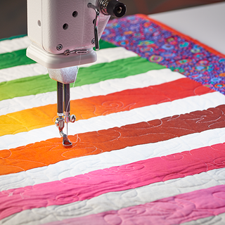 A Baby Lock Regent Longarm 18" Quilting Machine sewing a quilt.