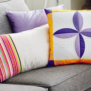 A Pfaff Passport 3.0 pillow on a gray couch.