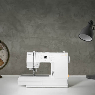 A PFAFF Passport 3.0 sewing machine sits on a table next to a globe.