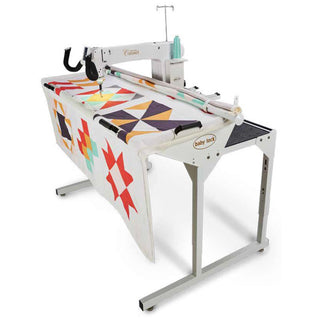 A Baby Lock Coronet Machine and Frame with a quilt on it.