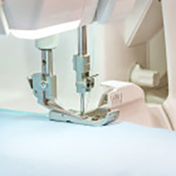 A Baby Lock Acclaim Serger is being used to sew a piece of fabric.