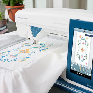 A Husqvarna Viking Designer Sapphire 85 sewing machine is being used to make a quilt.