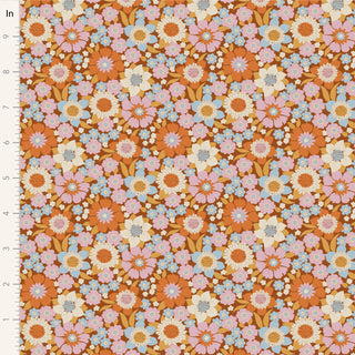 Tilda Wallflower Lauren Caramel TIL100604 by Fabric by Tilda is a 100% cotton fabric with seamless orange, pink, white, and blue floral prints on brown. Inch ruler shown at left for scale.
