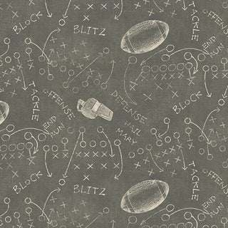 1684114B 16841-14 Playbook Steel Skyline Studio TOUCHDOWN fabric, a dark gray 100% cotton material patterned with white sketches of football plays, whistles, and footballs.