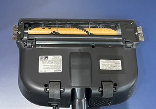 Bottom view of a Sew & Vac Oreck Elevate Cordless showing rollers, brushes, and informational labels on a blue background.