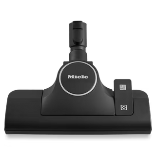 The Miele SBD 365-3 AllTeQ Eco Floor Nozzle, a black floor head attachment from Miele, is featured against a plain white background with the brand logo and control switch clearly visible—this versatile accessory is designed to deliver effective cleaning performance on multiple surfaces.