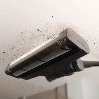 Close-up of the Miele Triflex HX3 Cordless Stick Vacuum in Brilliant White, effectively removing dirt and debris from a hard floor surface.