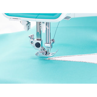 Close-up of a PFAFF Smarter By Pfaff 260c sewing machine needle stitching white fabric onto a turquoise background.