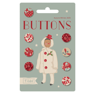 The Tilda Merry Little Christmas 400073 by Fabric by Tilda features a card with eight 0.47-inch decorative red and beige buttons and an illustration of a person in winter attire, reminiscent of vintage Christmas fabric charm.