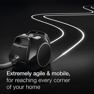 A black 2-Miele Boost CX1 Cat & Dog bagless vacuum glides across a shiny surface, white lines tracing its cleaning path. Text reads: “Extremely agile and mobile for reaching every corner of your home—and perfect for powerful pet hair removal.”.