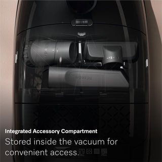 Image shows the transparent compartment of a 2-Miele Guard M1 Cat & Dog bagged canister vacuum, with multiple attachments neatly stored inside. Text reads: “Integrated Accessory Compartment. Keep all tools inside your vacuum for easy access—ideal for tackling pet hair.”.