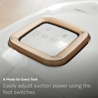 Close-up of the 2-Miele Guard L1 AllFloor bagged vacuum cleaner control panel, displaying various mode icons and a message about adjusting suction power via foot switches; equipped with advanced AirClean Plus filtration for enhanced air quality.