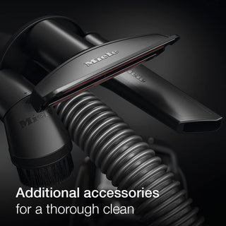 Close-up of 2-Miele Boost CX1 Cat & Dog vacuum accessories, including a hose, brush, and nozzle—perfect for removing pet hair—displayed with text: “Additional accessories for a thorough clean.” Dark background.