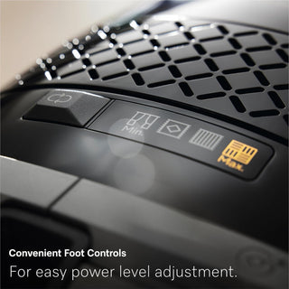 Close-up of the Miele Guard M1 Cat & Dog canister vacuum’s control panel, featuring labeled buttons with icons for easy foot-operated power level adjustment, including a “Max” setting. Text reads: “Convenient Foot Controls. For easy power level adjustment.” Ideal for homes with pets, the 2-Miele model also features an Active AirClean filter for fresher indoor air.