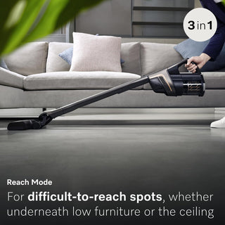 Using the Miele Triflex HX2 Pro 3-in-1 Cordless Stick Vacuum by 2-Miele, a person easily cleans under a couch in the living room by extending the handle in reach mode. The vacuum’s versatile 3-in-1 design provides convenient cleaning for difficult-to-reach spots.