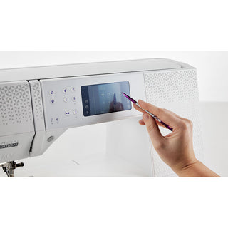 A hand uses a stylus to navigate the touchscreen display of the Pfaff Expression 710 SPECIAL EDITION by Imagine Sewing & Vacuum, featuring the innovative IDT System for precise fabric control.