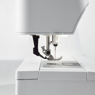 Close-up of the needle and presser foot area of the Pfaff Expression 710 SPECIAL EDITION from Imagine Sewing & Vacuum, featuring detailed machine parts and the advanced IDT System.