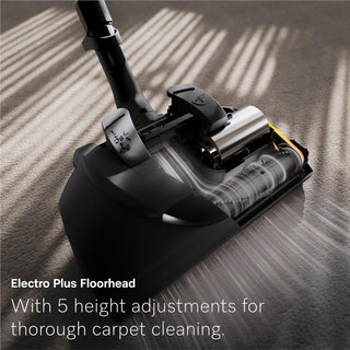 Close-up of the 2-Miele Guard L1 Electro canister vacuum’s Electro Plus floorhead on carpet, highlighting internal components and bristles. Overlay text emphasizes its five-height adjustments for deep carpet cleaning and an advanced AirClean Filter for improved air quality.
